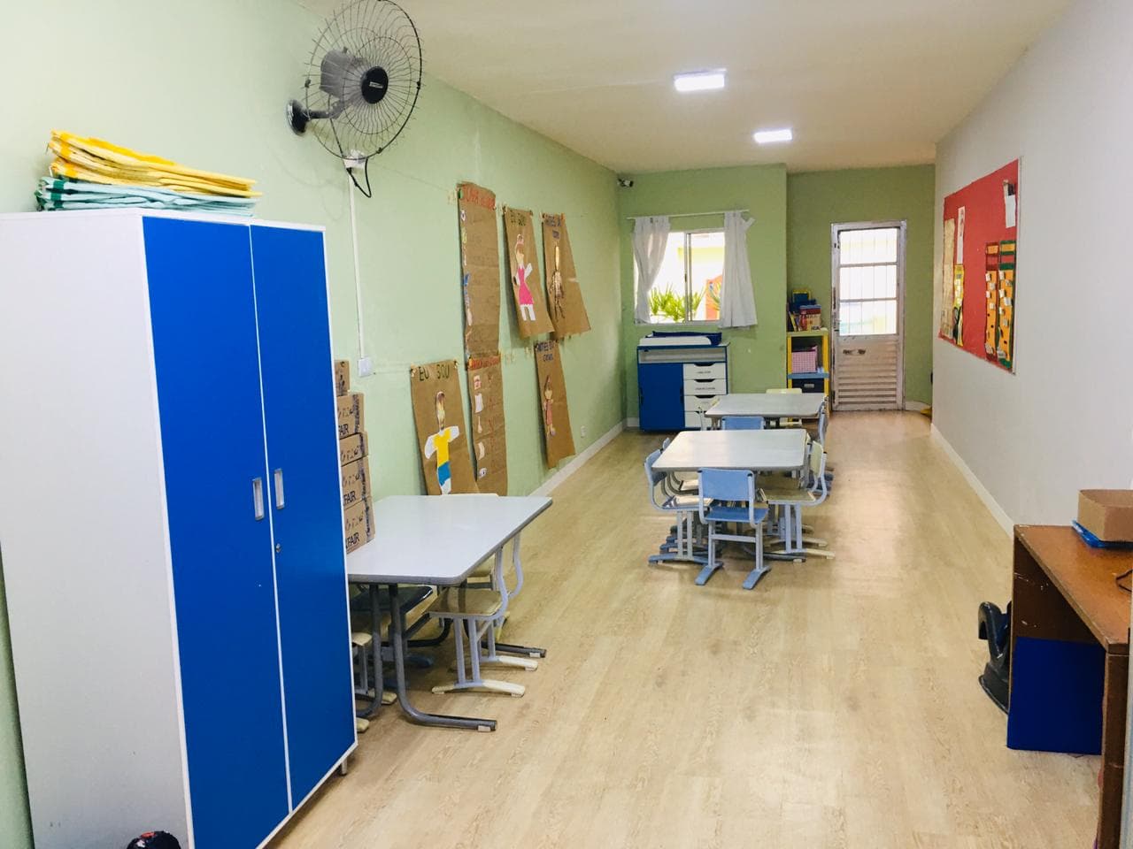 Sala de projetos da Grow Up School com mesas individuais e trabalhos dos alunos expostos na parede